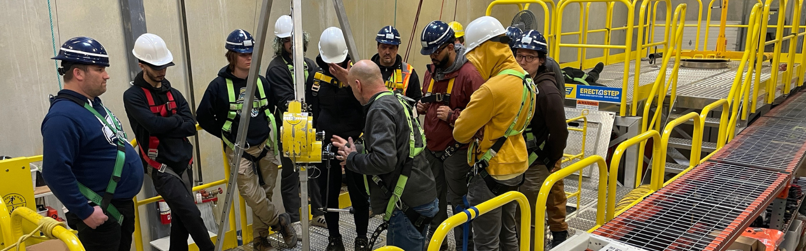 Confined space training, people with hard hats following a confined space training, davit arm, hard hats, safety, health and safety
